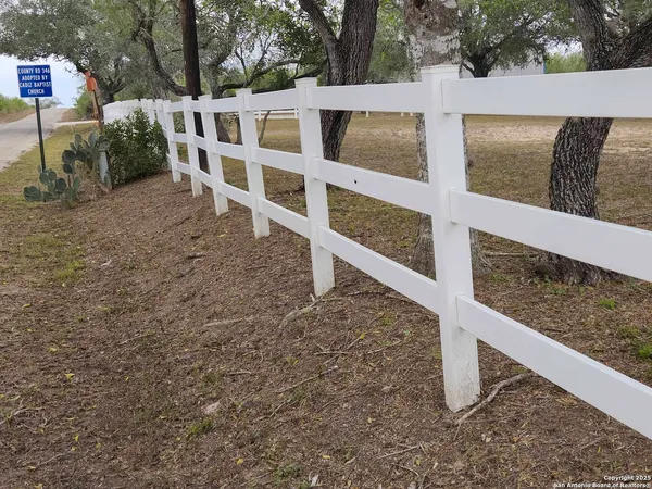 a view of a dry yard with wooden fence