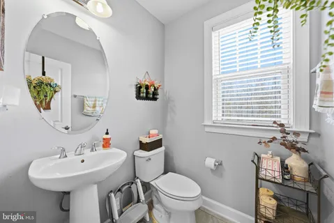 a bathroom with a sink toilet and a mirror