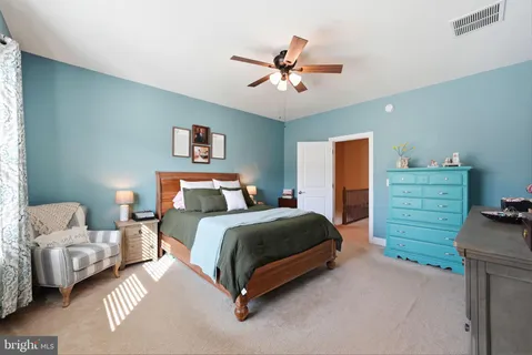 a spacious bedroom with a bed and a ceiling fan