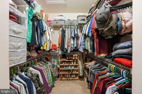 a view of walk in closet with clothes and shoes