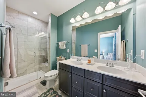 a bathroom with a sink double vanity granite toilet and shower