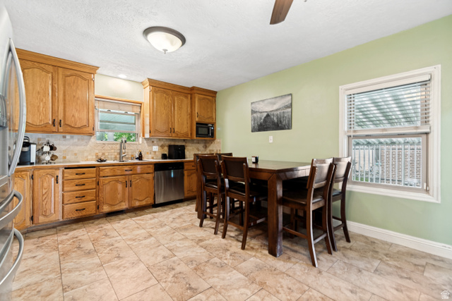 127 West 300 North Springville, UT 84663 - Photo 9 of 24 Kitchen featuring wood cabinetry, stainless steel appliances, tile backsplash, and tile flooring