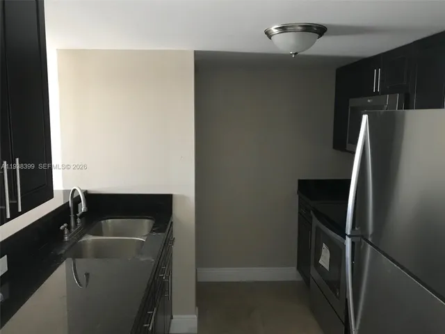 a kitchen with a refrigerator and a sink
