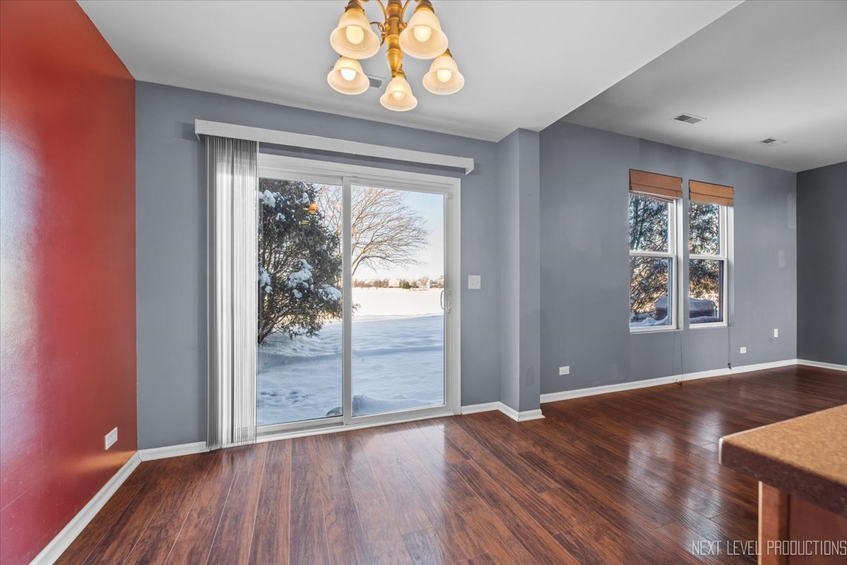 643 Hawley Drive, Unit 643 Oswego, IL 60543 - Photo 11 of 27 an empty room with wooden floor and windows