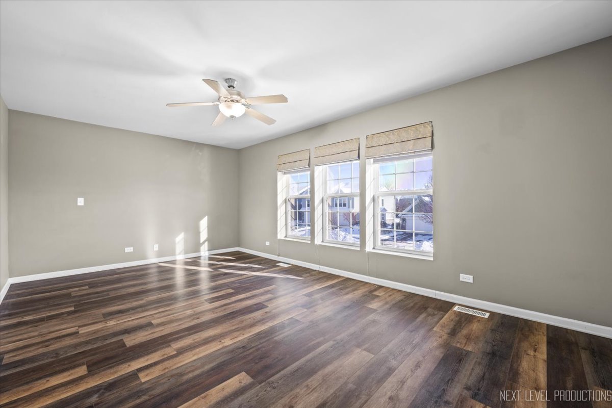 643 Hawley Drive, Unit 643 Oswego, IL 60543 - Photo 18 of 27 wooden floor in an empty room with a window