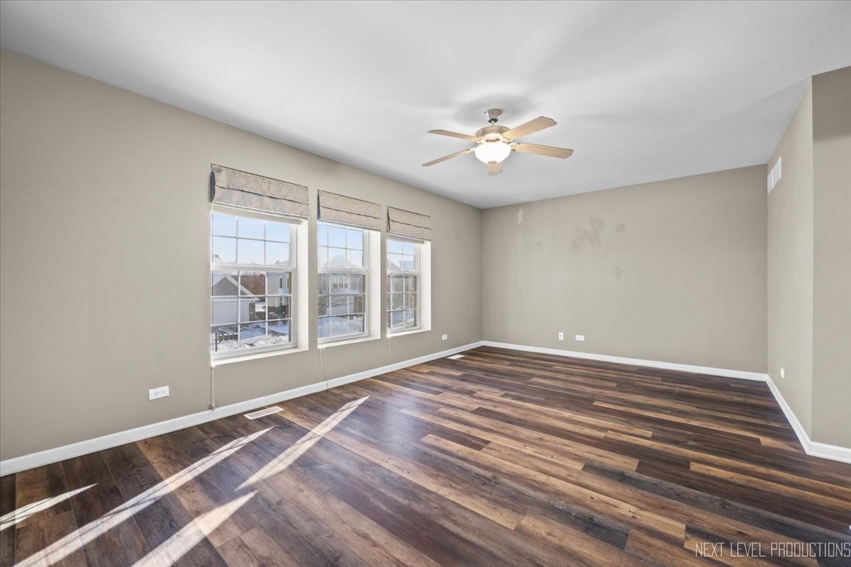 643 Hawley Drive, Unit 643 Oswego, IL 60543 - Photo 19 of 27 a view of an empty room with a window and a ceiling fan