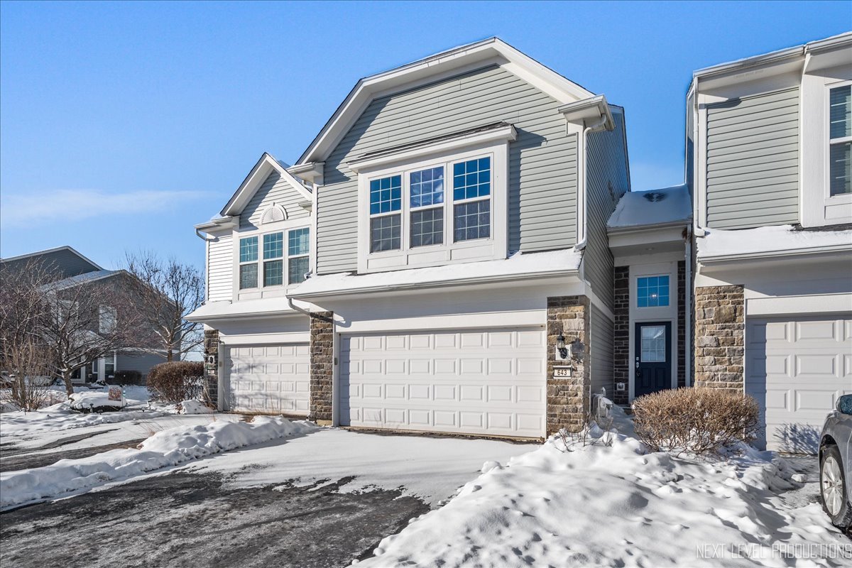 643 Hawley Drive, Unit 643 Oswego, IL 60543 - Photo 2 of 27 a front view of a house with a yard and garage