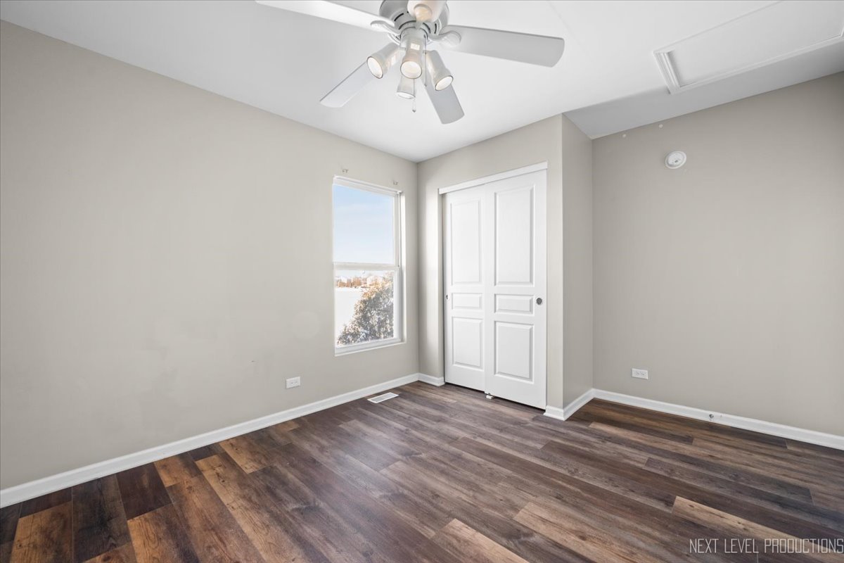 643 Hawley Drive, Unit 643 Oswego, IL 60543 - Photo 21 of 27 an empty room with wooden floor and windows