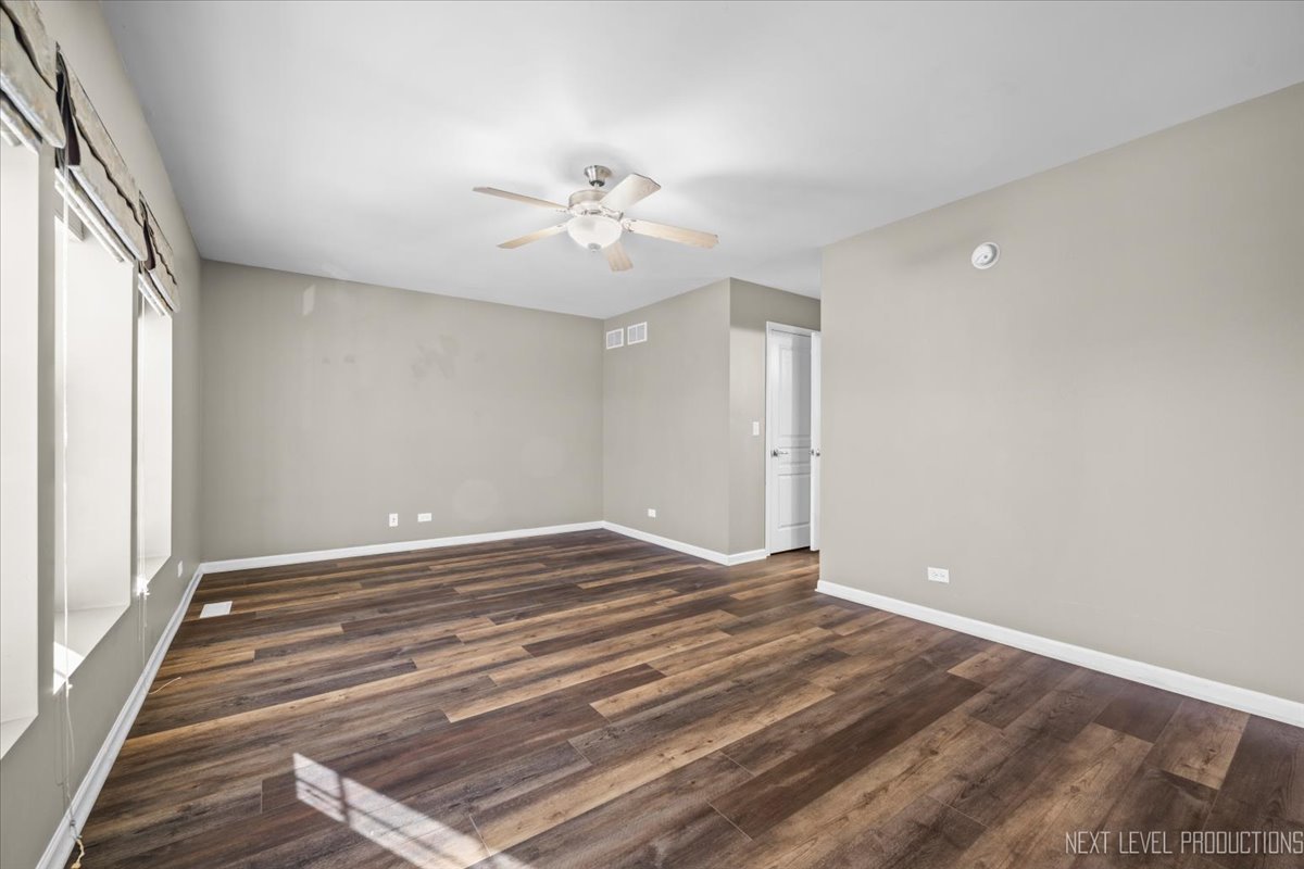 643 Hawley Drive, Unit 643 Oswego, IL 60543 - Photo 25 of 27 a view of empty room with wooden floor and fan