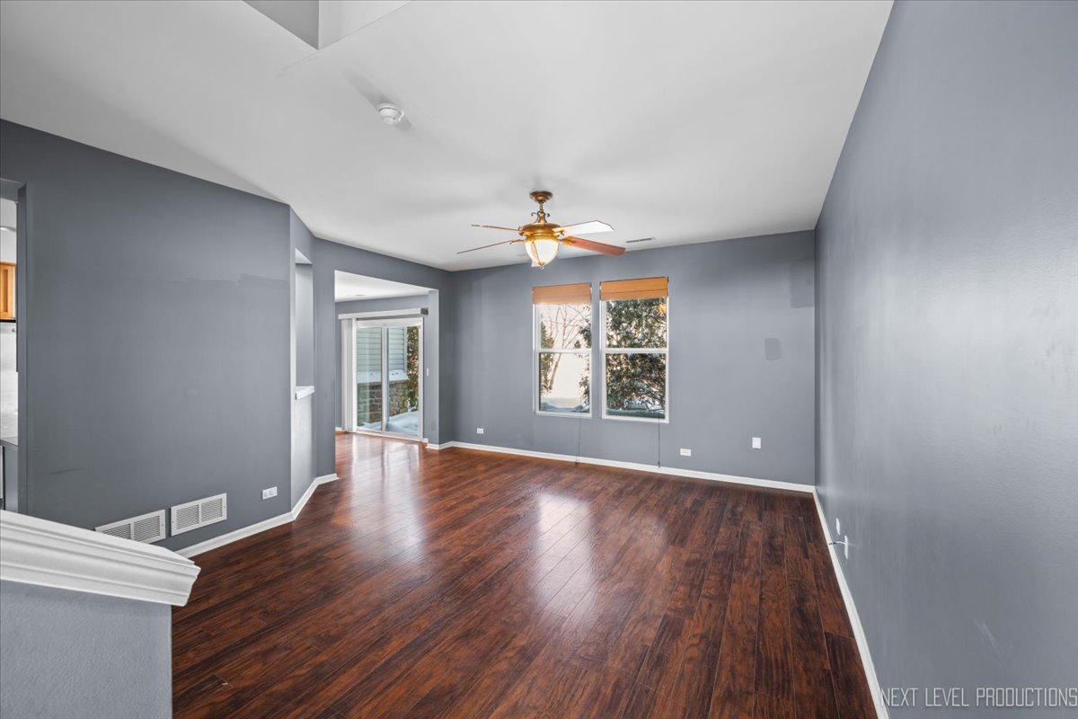 643 Hawley Drive, Unit 643 Oswego, IL 60543 - Photo 4 of 27 wooden floor in an empty room with a window