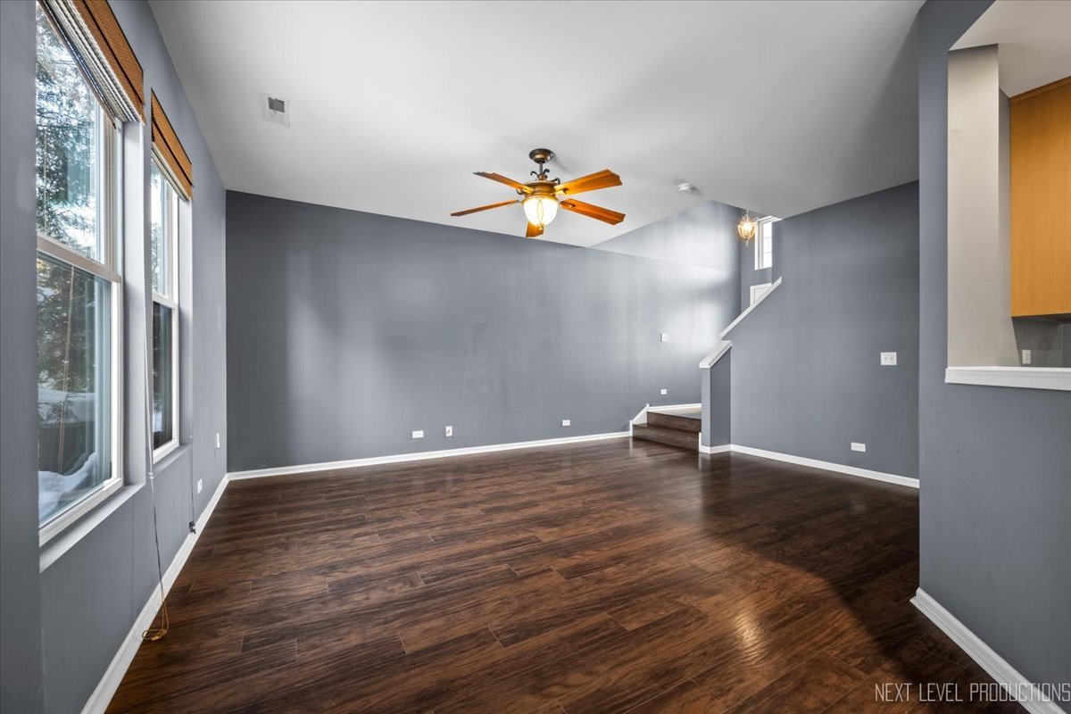 643 Hawley Drive, Unit 643 Oswego, IL 60543 - Photo 6 of 27 a view of an empty room with a window and wooden floor