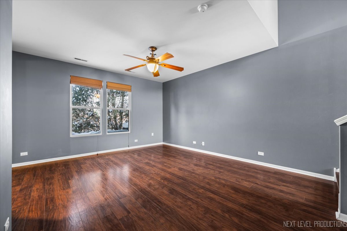643 Hawley Drive, Unit 643 Oswego, IL 60543 - Photo 7 of 27 wooden floor in an empty room with a window