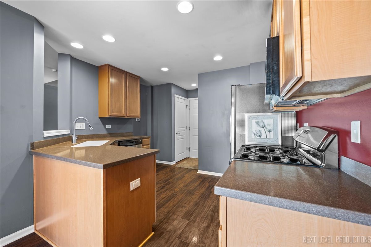 643 Hawley Drive, Unit 643 Oswego, IL 60543 - Photo 10 of 27 a kitchen with stainless steel appliances granite countertop a sink a stove and a refrigerator