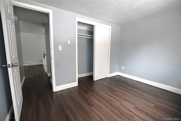 an empty room with wooden floor and closet