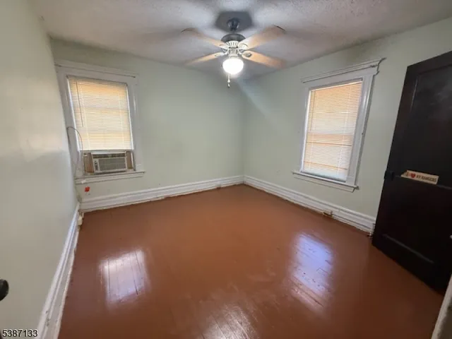 an empty room with a window and wooden floor