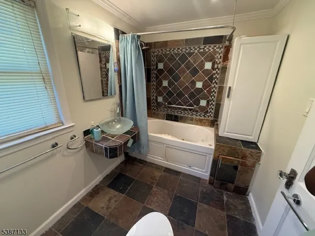 a bathroom with a tub shower vanity and a sink