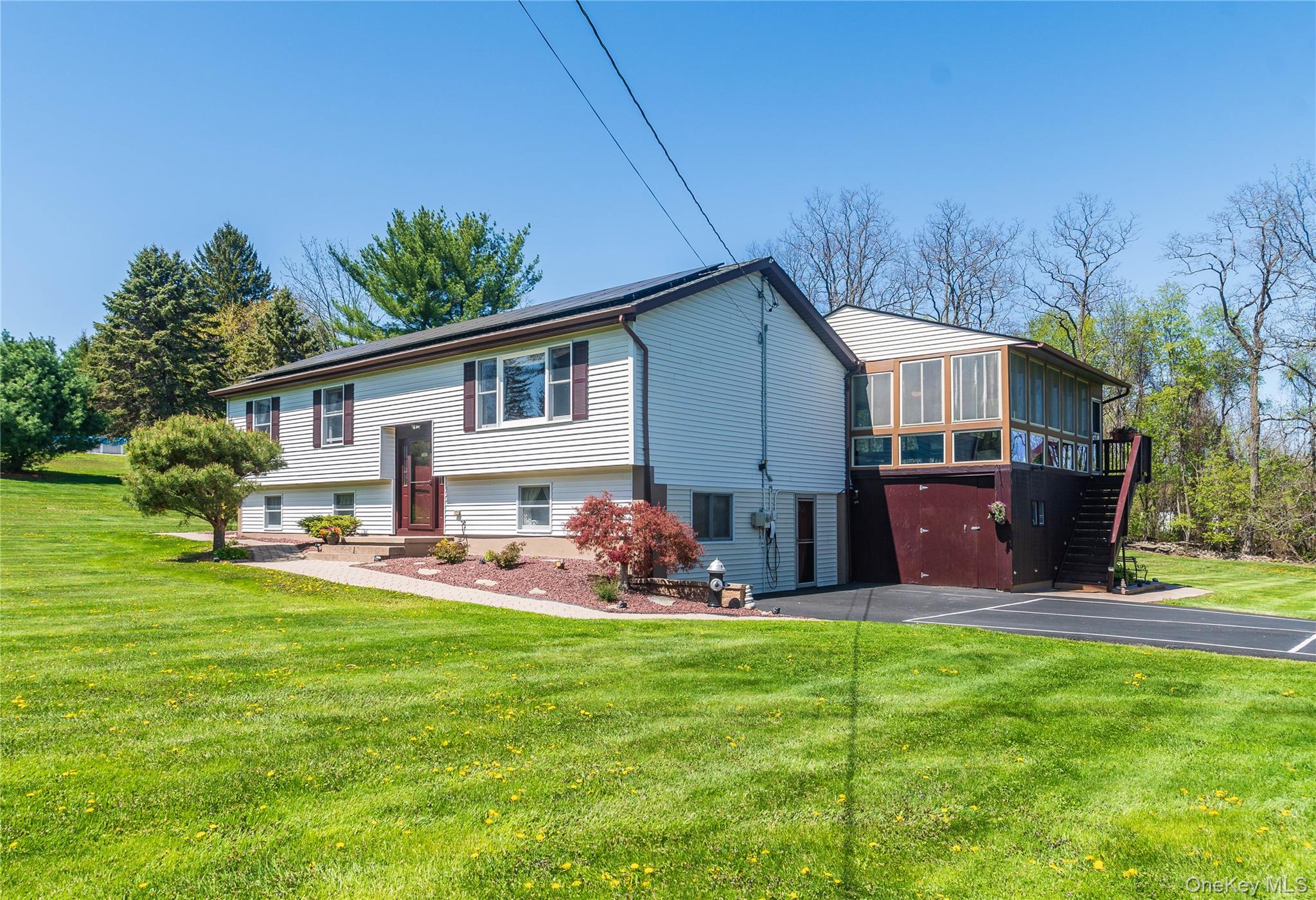 Split-level residence featuring almond siding, brown shutters, and a covered entry