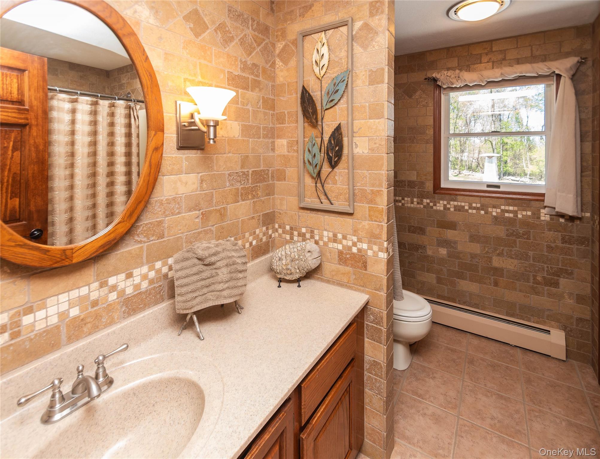3 Duby Road Wallkill, NY 12589 - Photo 20 of 40 Bathroom featuring full-height tiled tumbled marbled walls, a window with outdoor scenery, and a built-in vanity with an integrated sink