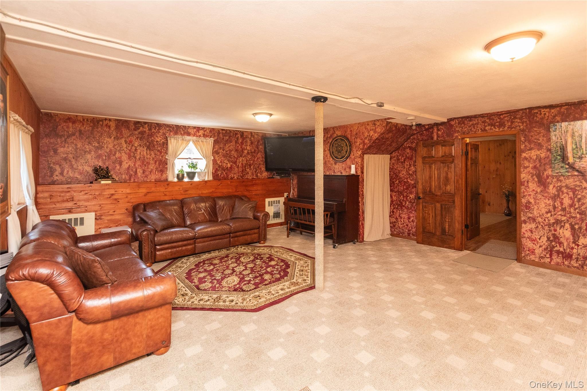 3 Duby Road Wallkill, NY 12589 - Photo 33 of 40 Spacious finished lower level featuring patterned carpet flooring, a wood-paneled accent wall, and a solid wood door