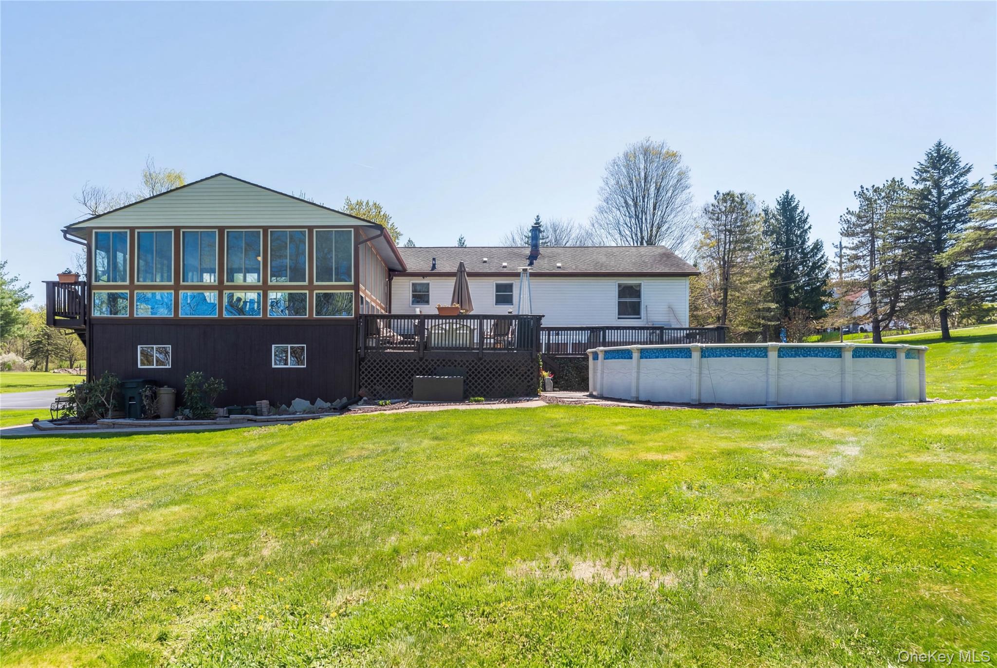 3 Duby Road Wallkill, NY 12589 - Photo 5 of 40 Expansive rear yard featuring a large above-ground pool, a multi-level deck, and a spacious sunroom with extensive window-line