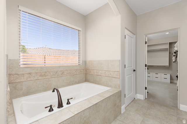 1257 West 2320 South St. George, UT 84770 - Photo 24 of 55 Soaking tub with bronze-finish fixtures, surrounded by light-toned tile with a decorative accent band