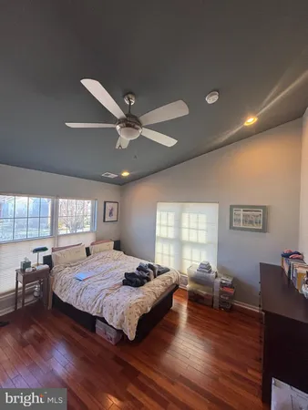 a spacious bedroom with a large bed a chandelier and windows