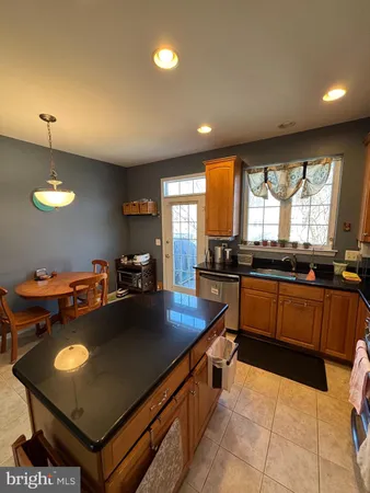 a kitchen with stainless steel appliances granite countertop a sink a stove counter space and a window