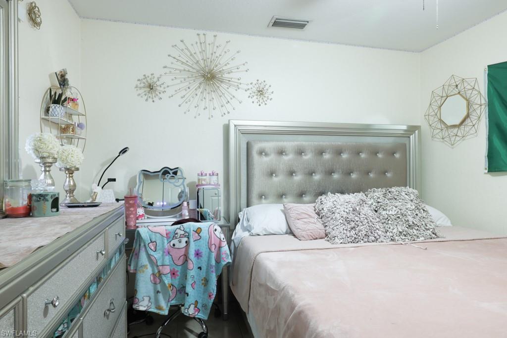 2300 Hunter Boulevard Naples, FL 34116 - Photo 11 of 16 a bedroom with a bed and a chandelier