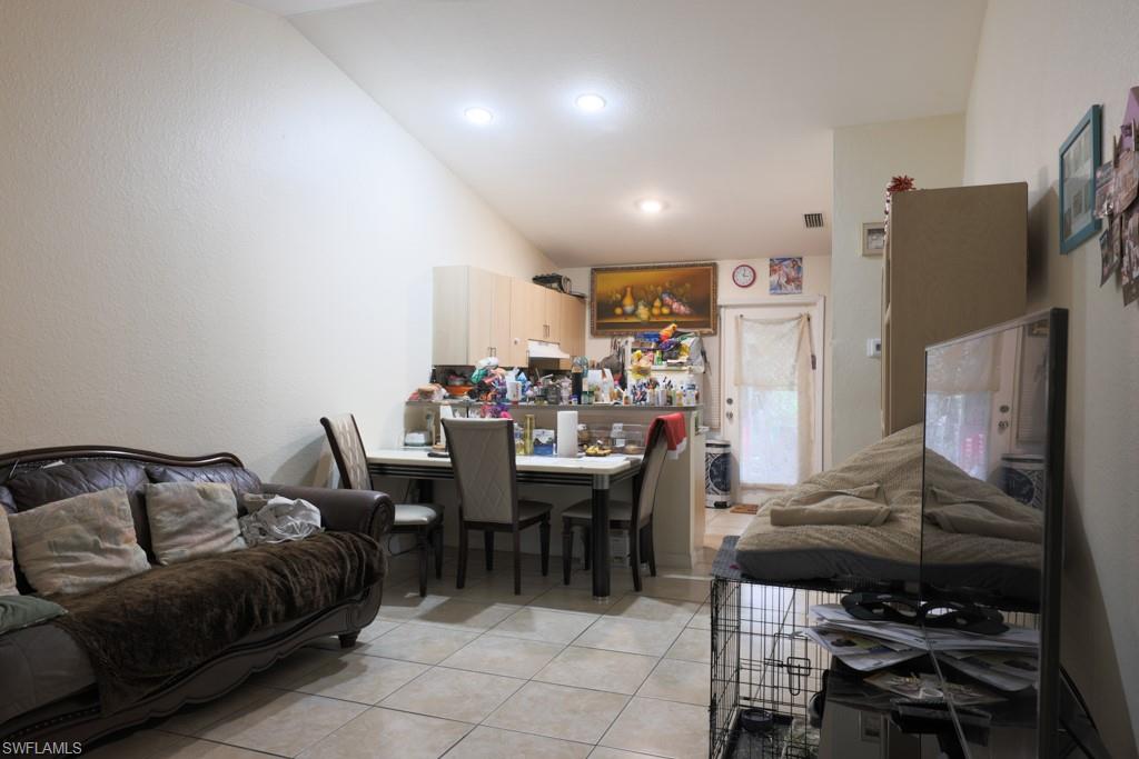 2300 Hunter Boulevard Naples, FL 34116 - Photo 2 of 16 a living room with furniture a table and a refrigerator