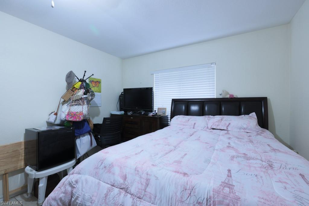 2300 Hunter Boulevard Naples, FL 34116 - Photo 5 of 16 a bedroom with a bed and a flat tv screen on a dresser