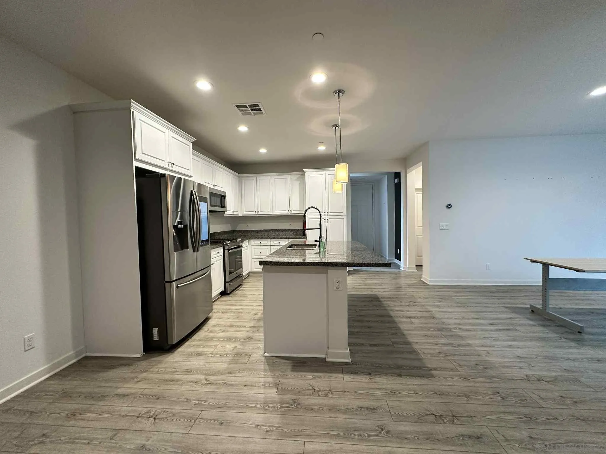 1958 P.º Lugo Chula Vista, CA 91913 - Photo 15 of 68 a kitchen with stainless steel appliances kitchen island granite countertop a refrigerator and a stove top oven