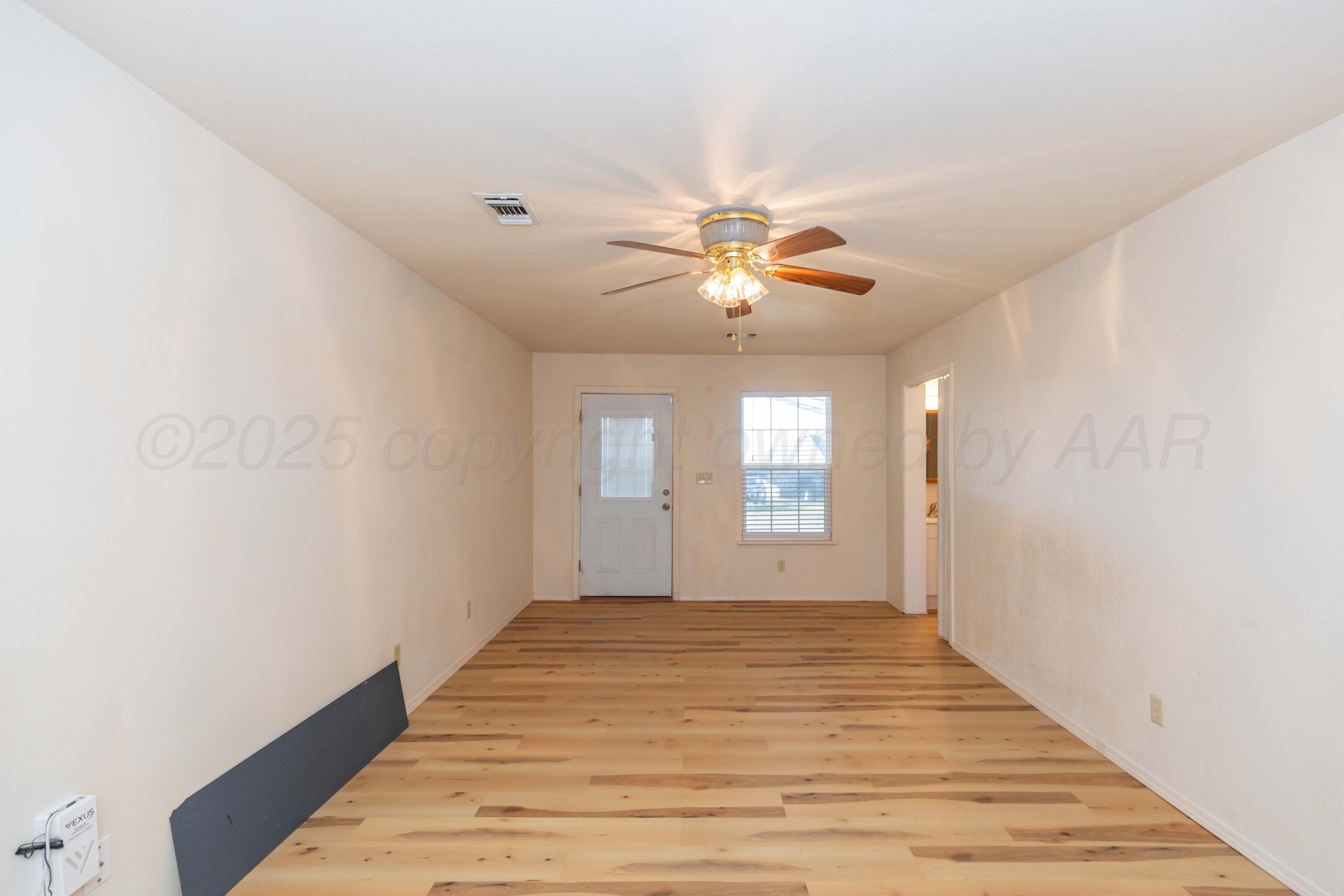 5230 Royce Drive Amarillo, TX 79110 - Photo 21 of 57 a view of an empty room with window and wooden floor