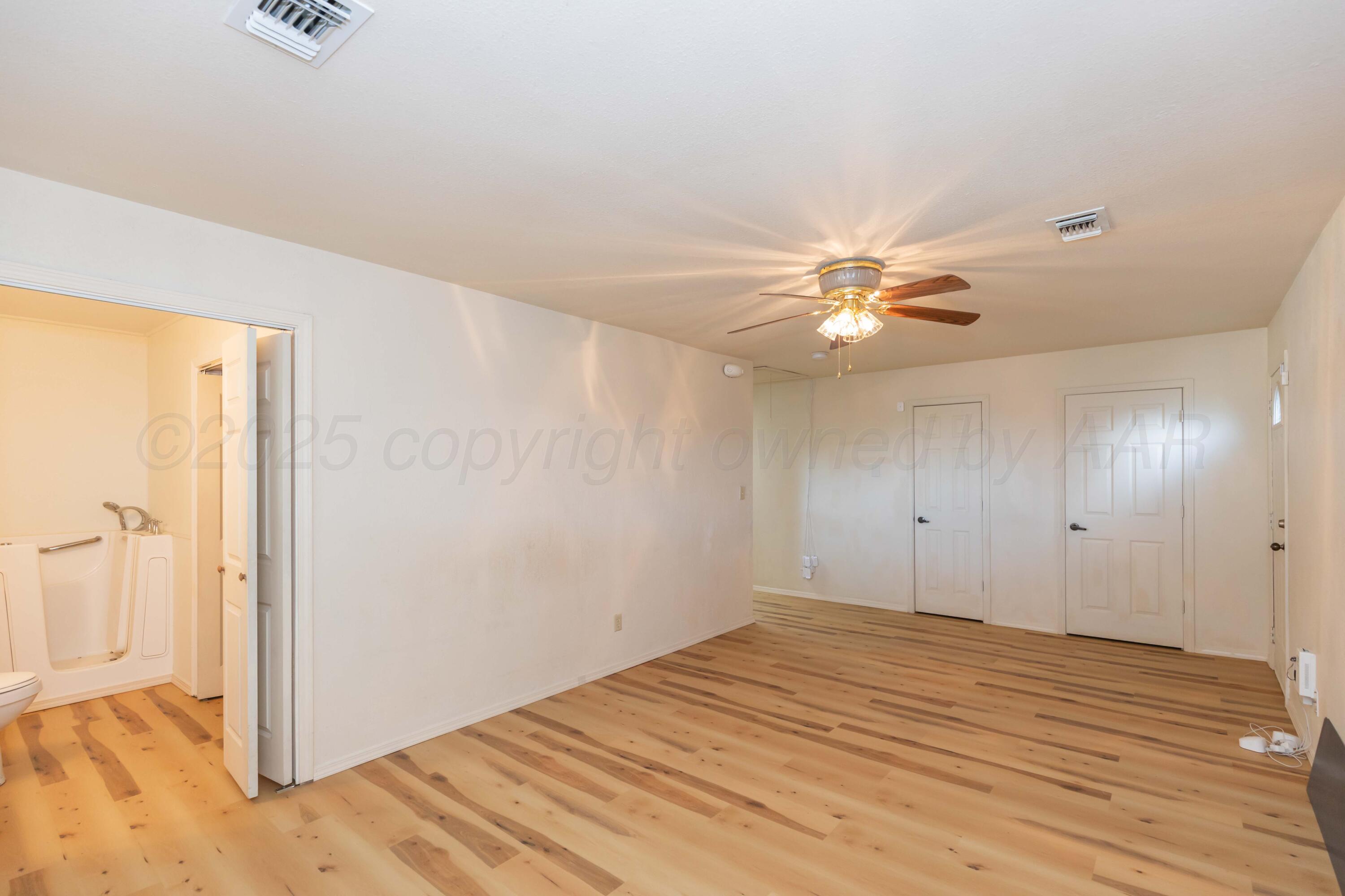 5230 Royce Drive Amarillo, TX 79110 - Photo 22 of 57 a view of a livingroom with a ceiling fan and wooden floor