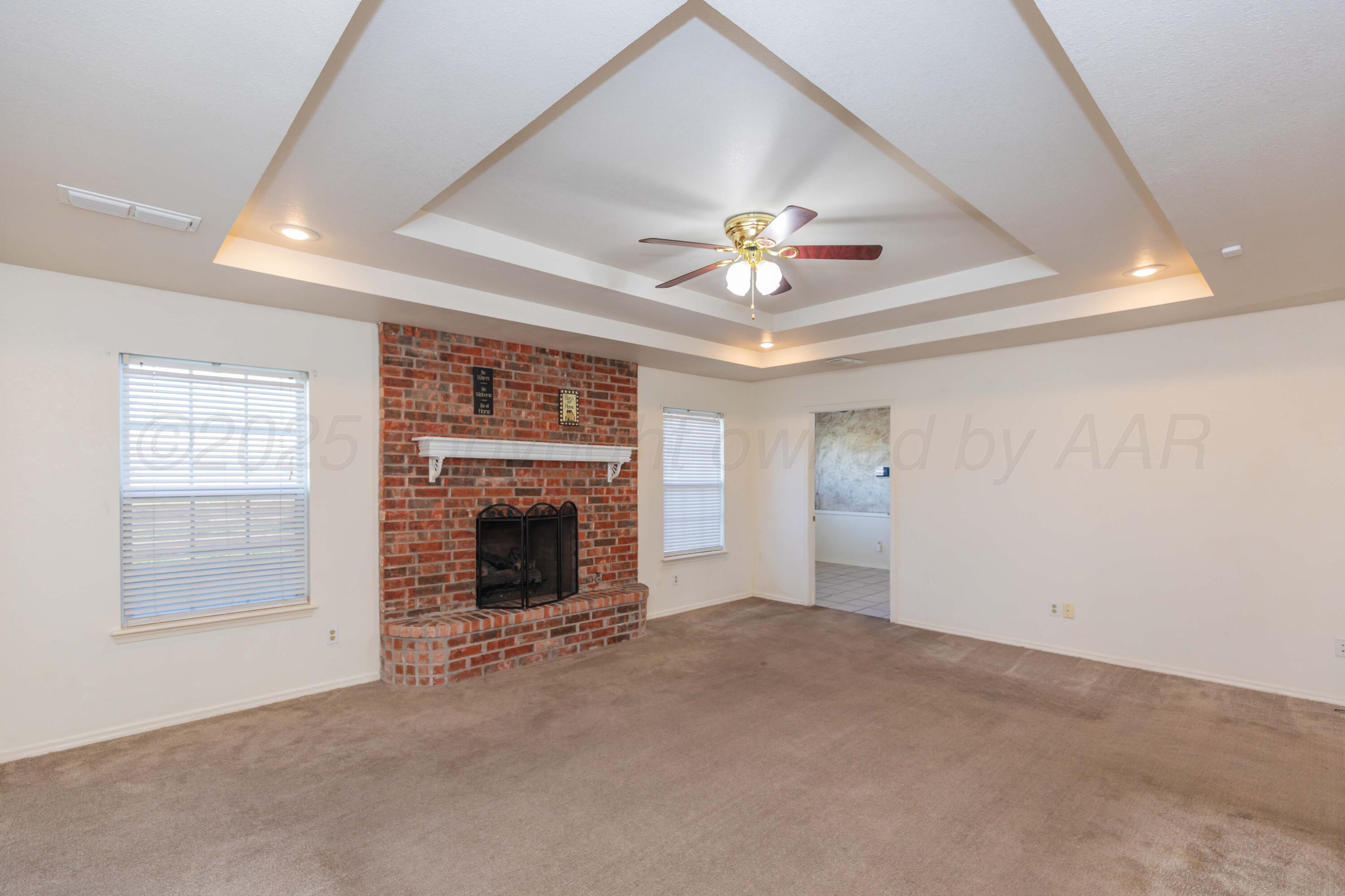 5230 Royce Drive Amarillo, TX 79110 - Photo 5 of 57 an empty room with a fireplace and fan