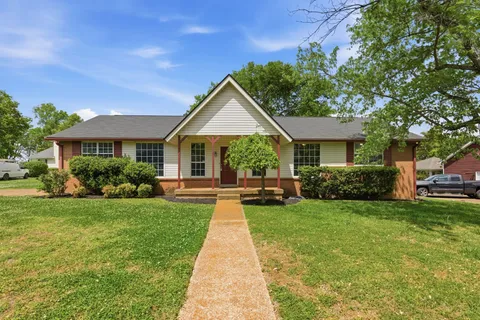 a front view of a house with yard patio and green space