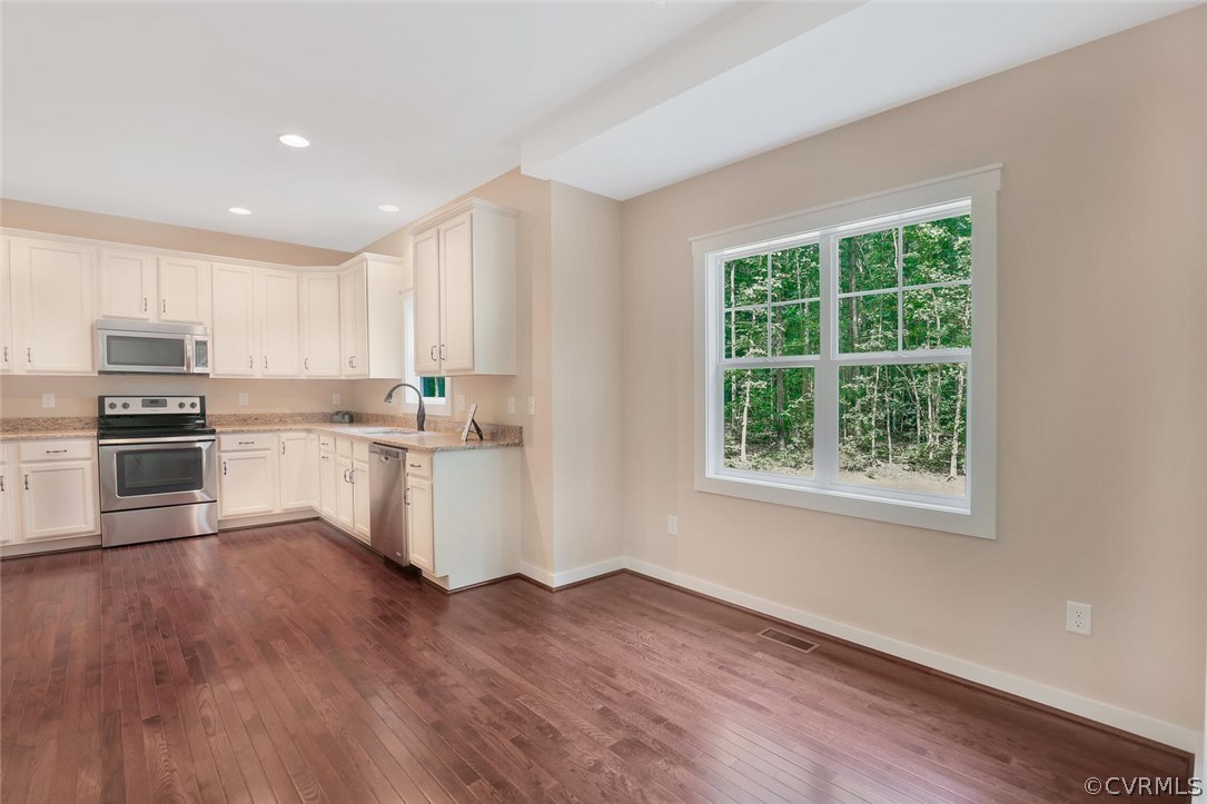 19410 River Road Chesterfield, VA 23838 - Photo 13 of 32 a kitchen with wooden floors and stainless steel appliances