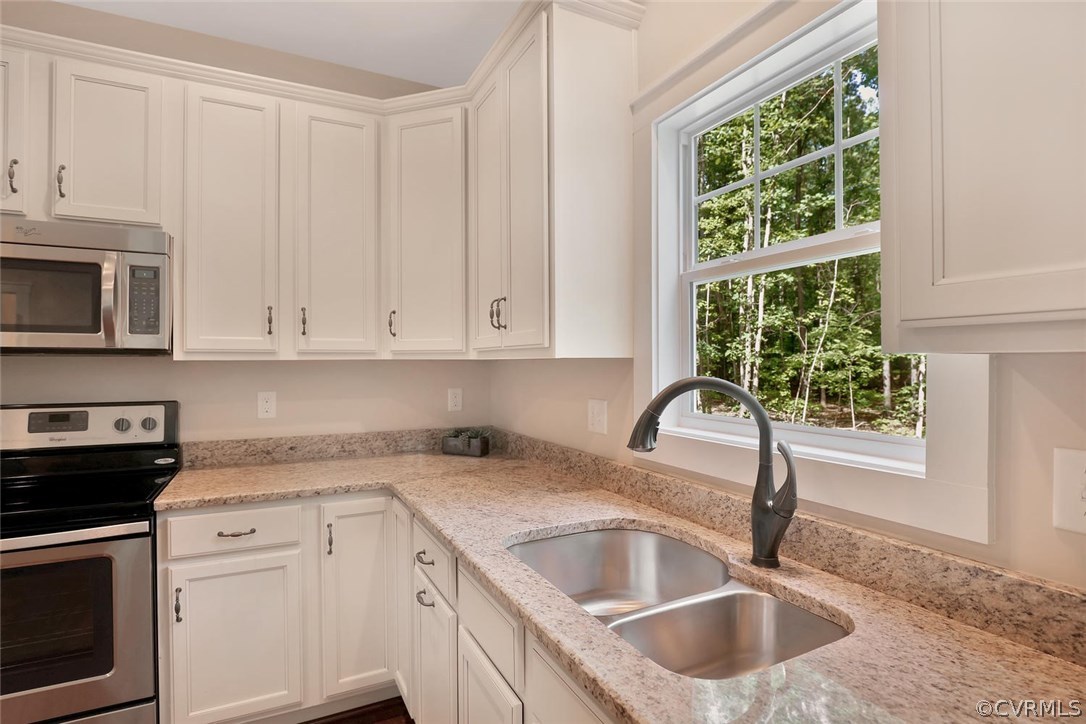 19410 River Road Chesterfield, VA 23838 - Photo 16 of 32 a kitchen with granite countertop a sink a stove and microwave
