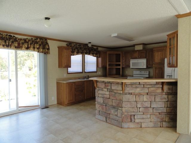 315 Ramsey Green Road Manchester, TN 37355 - Photo 3 of 20 Kitchen has an abundance of cabinets, bar, stove, dishwasher & refrigerator. Patio door leads you to a wonderful view that looks over the ponds and 13 + acres.