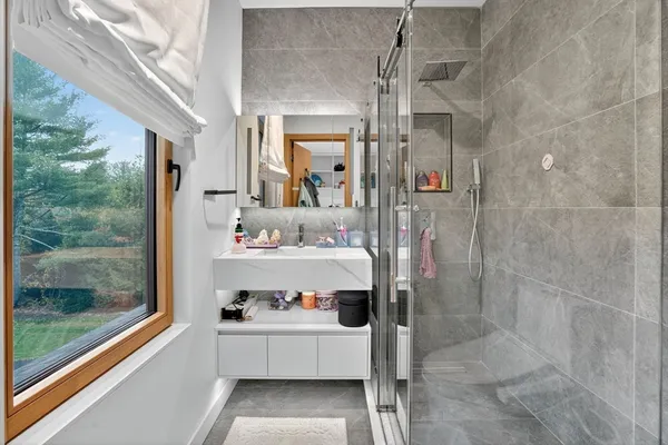 a bathroom with a sink and mirror with bathtub
