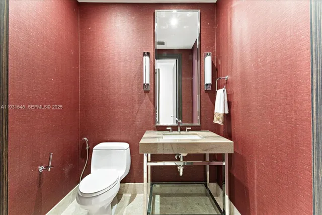 a bathroom with a toilet a sink and mirror