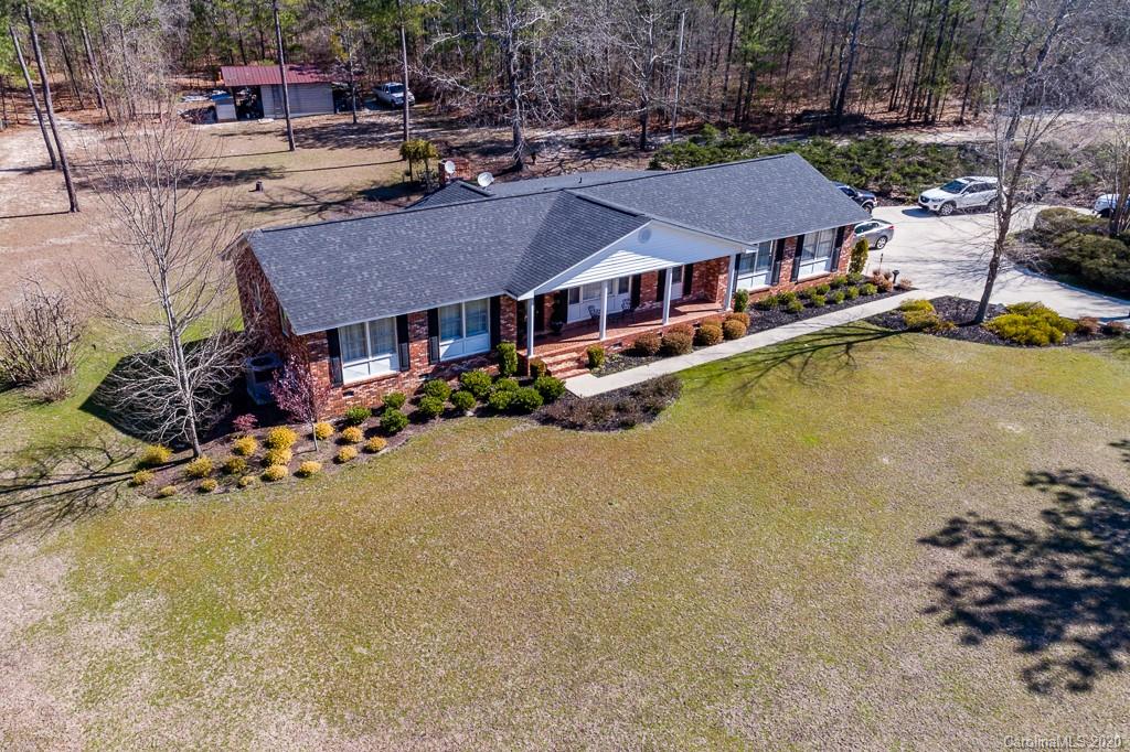 a aerial view of a house with swimming pool and large trees