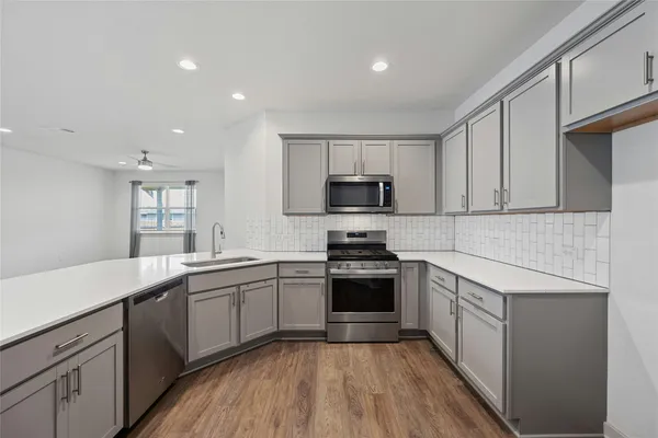 a kitchen with sink a microwave and cabinets