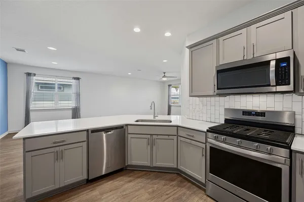 a kitchen with a sink stove and microwave