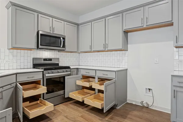 a kitchen with granite countertop a stove and a microwave