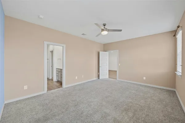 a view of an empty room with a ceiling fan
