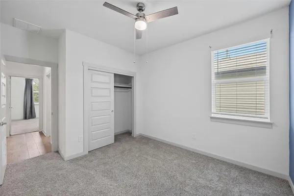 an empty room with closet and fan