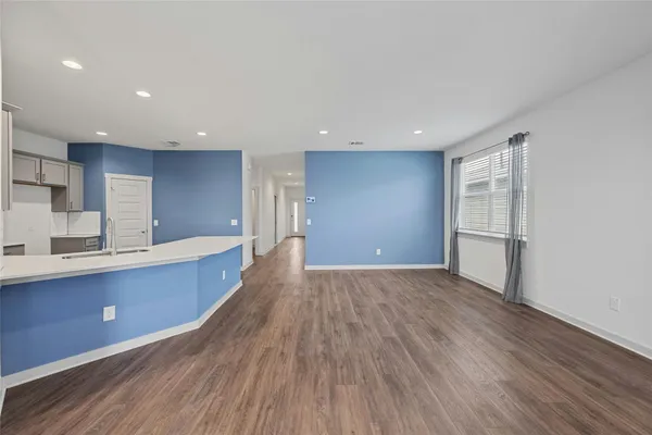 a large kitchen with wooden floors and stainless steel appliances