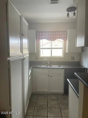 a room with a sink cabinets and stainless steel appliances