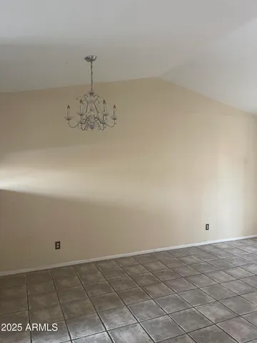 an empty room with a chandelier fan