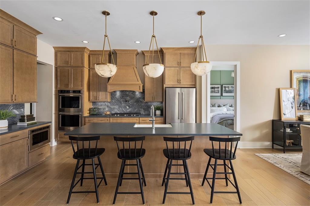 214 Mooney Road Woodstock, GA 30188 - Photo 2 of 17 a kitchen with stainless steel appliances kitchen island granite countertop a table chairs and a refrigerator